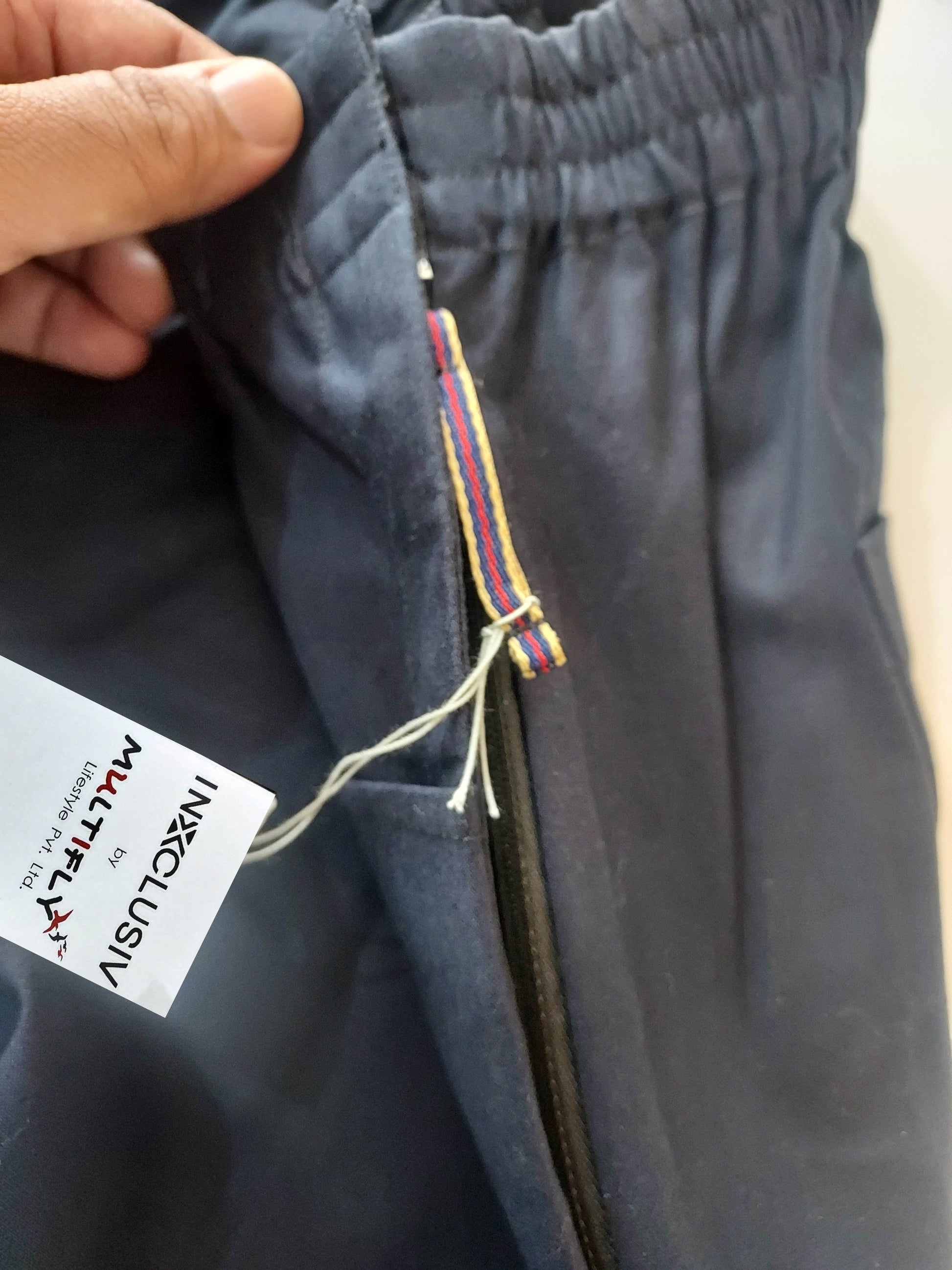 zipper on the side with puller tape visible on the wearer's left. Brand tag with INXCLUSIV by Multifly Lifestyle Pvt ltd is attached with the string on the zipper puller. 