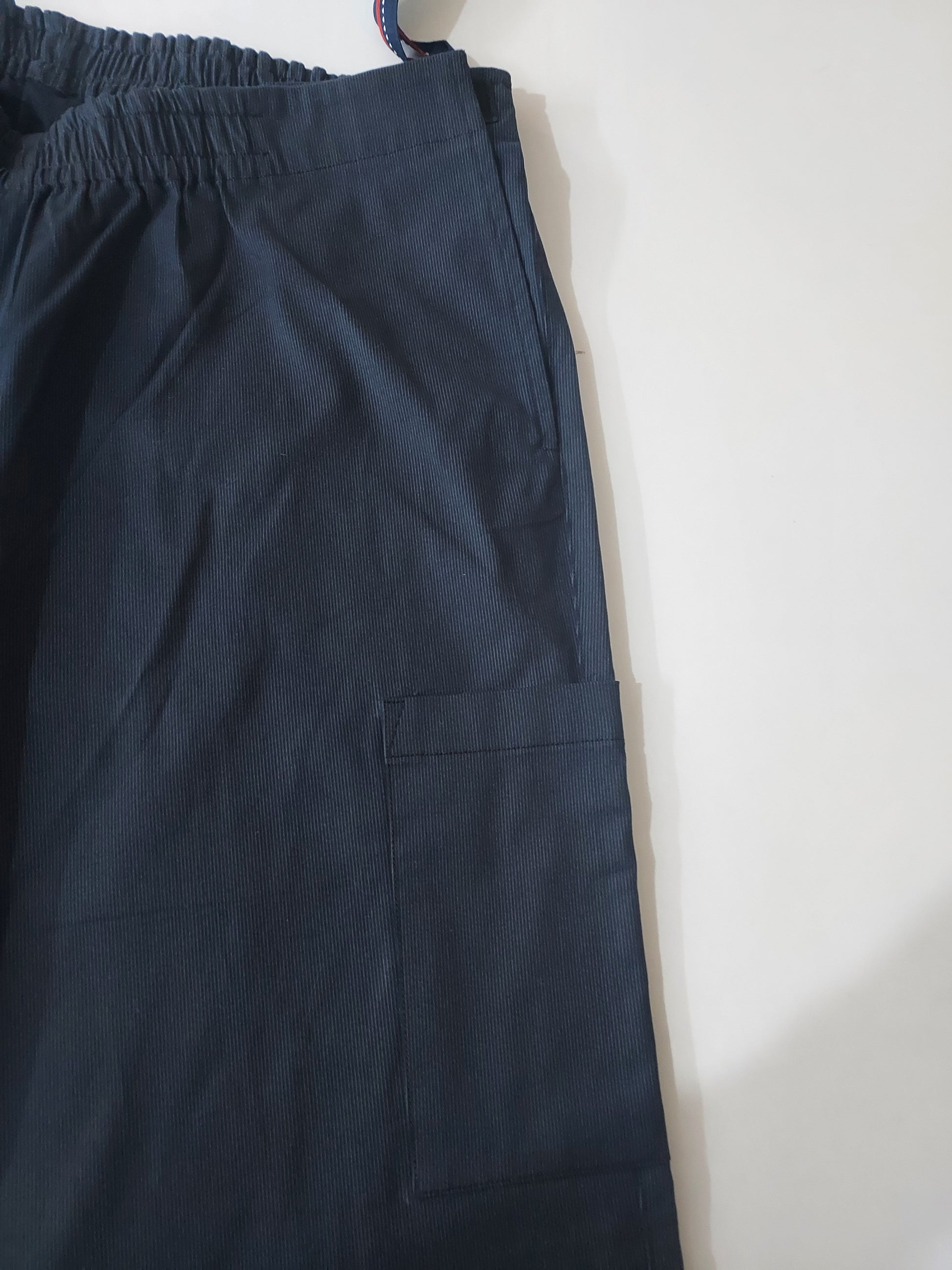 In this Picture, one can see the wearer's left side , mainly the region around the hips and thighs. the opening is visible, elastic on the waist band is visible on the front as well as back. there is a patch pocket on the thigh. 